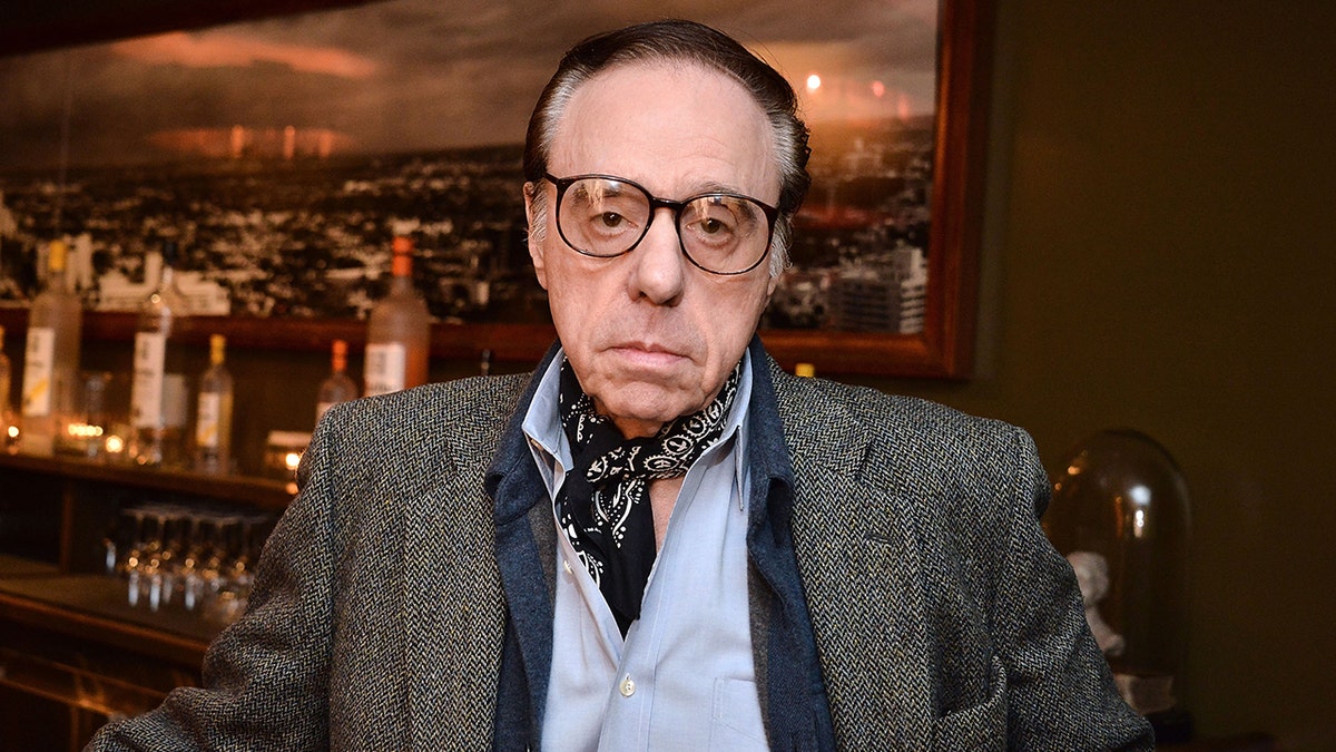 Peter Bogdanovich looks glum/frowns in a photo wearing a black bandana scarf and textured jacket