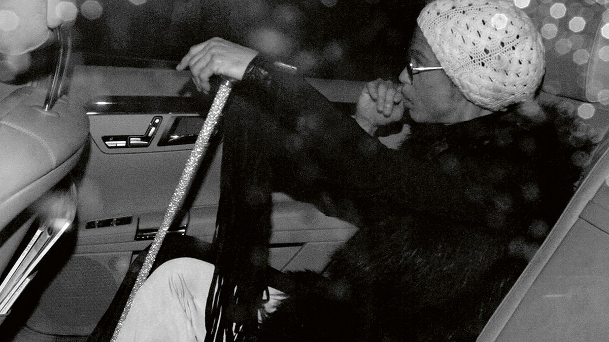 Prince made deliberate move to escape temptations of fame: pal Prince holding a cane and sitting in a car.
