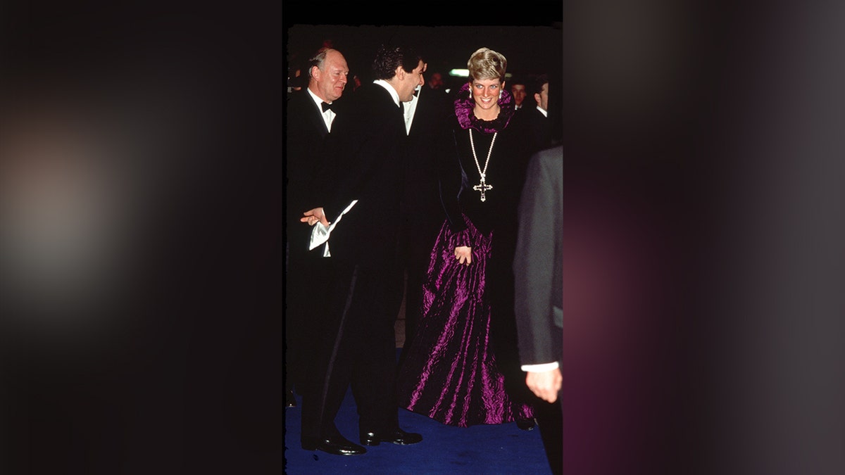 Princess Diana at a charity gala in 1987 wearing a cross pendant.