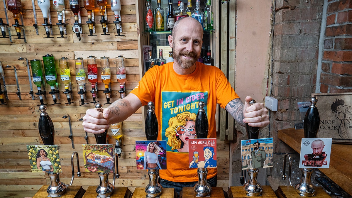 Man posing with his controversially named beers.