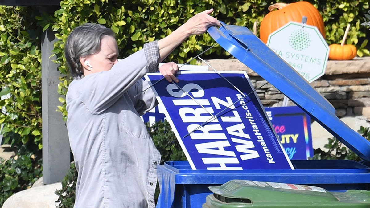 Sally Field lifts the recycling bin to trash a Harris-Walz sign