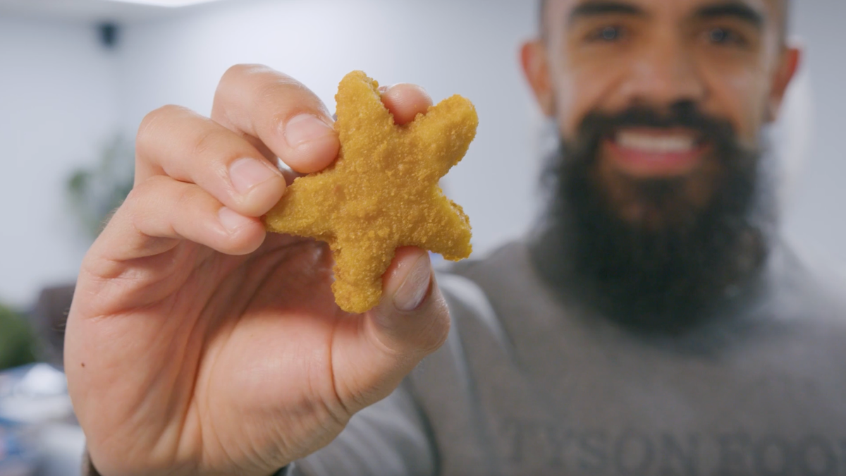 A Tyson Foods employee holds a Dallas Cowboys chicken nugget in his hand.