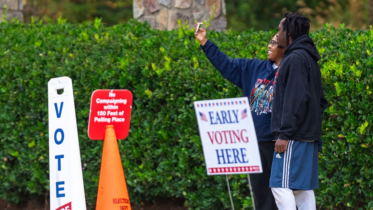 Two voters take a selfie after leaving the polling station on Thursday, Oct. 31, 2024, in Stockbridge, Georgia.