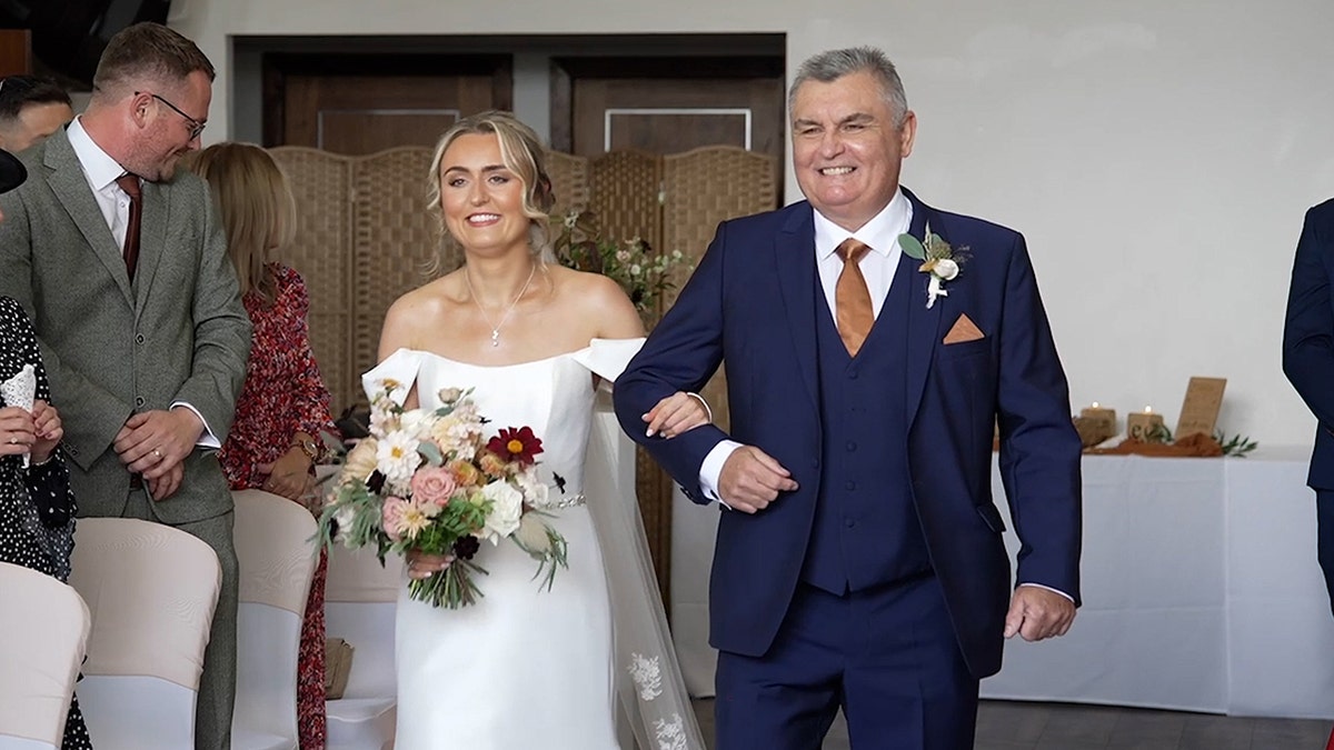 Bride and father walk down aisle