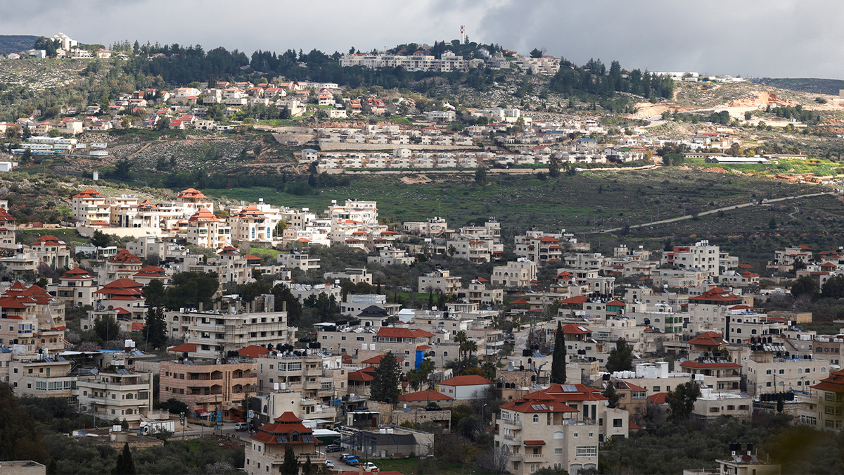 A photo taken in the village of Turmus Ayya, near the city of Ramallah, shows the nearby Israeli settlement of Shilo in the background in the occupied West Bank on February 18, 2024.