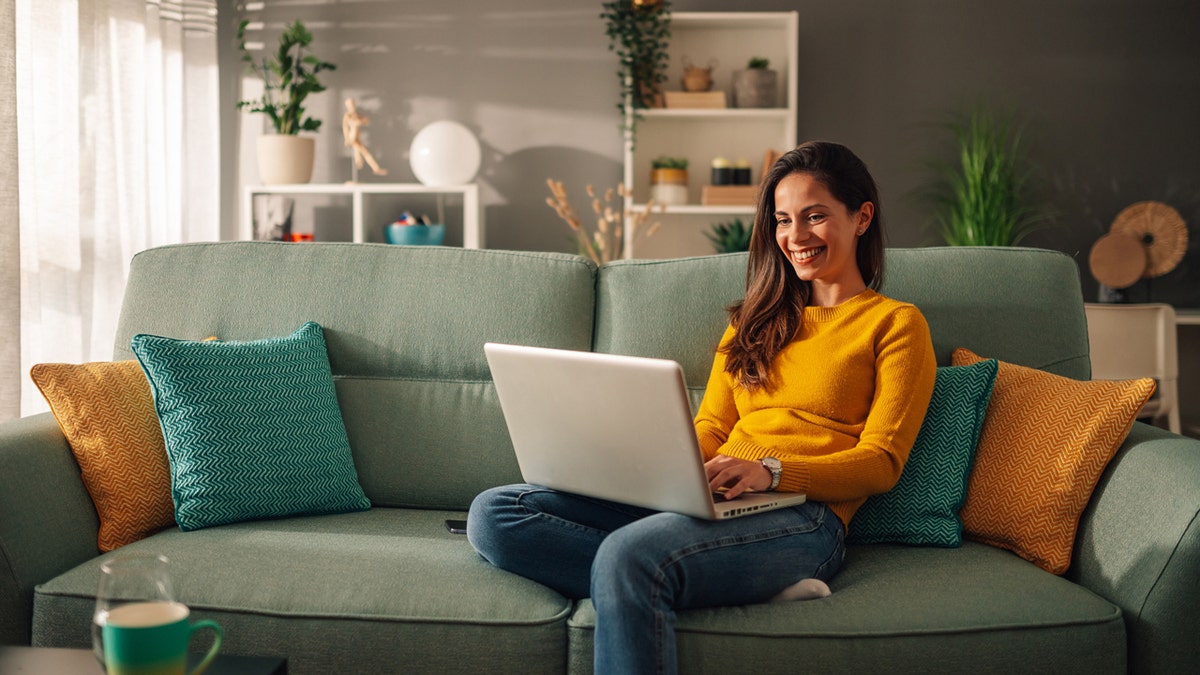 A person on her laptop while sitting on a couch