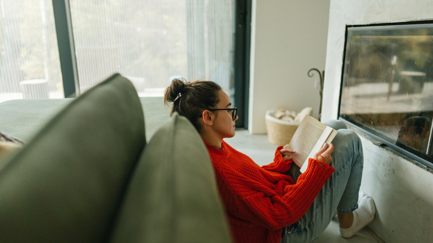 woman reading book fireplace