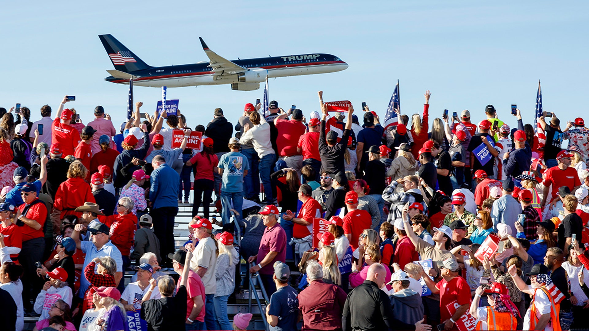 Supporters watch as Republican presidential nominee, former President Donald Trump lands before a campaign rally at Kinston Regional Jetport