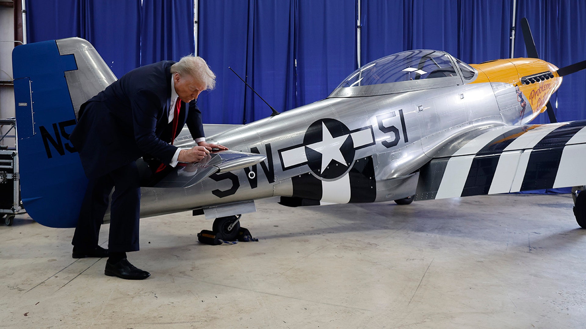 Donald Trump signs a North American Aviation P-51 Mustang at a campaign rally