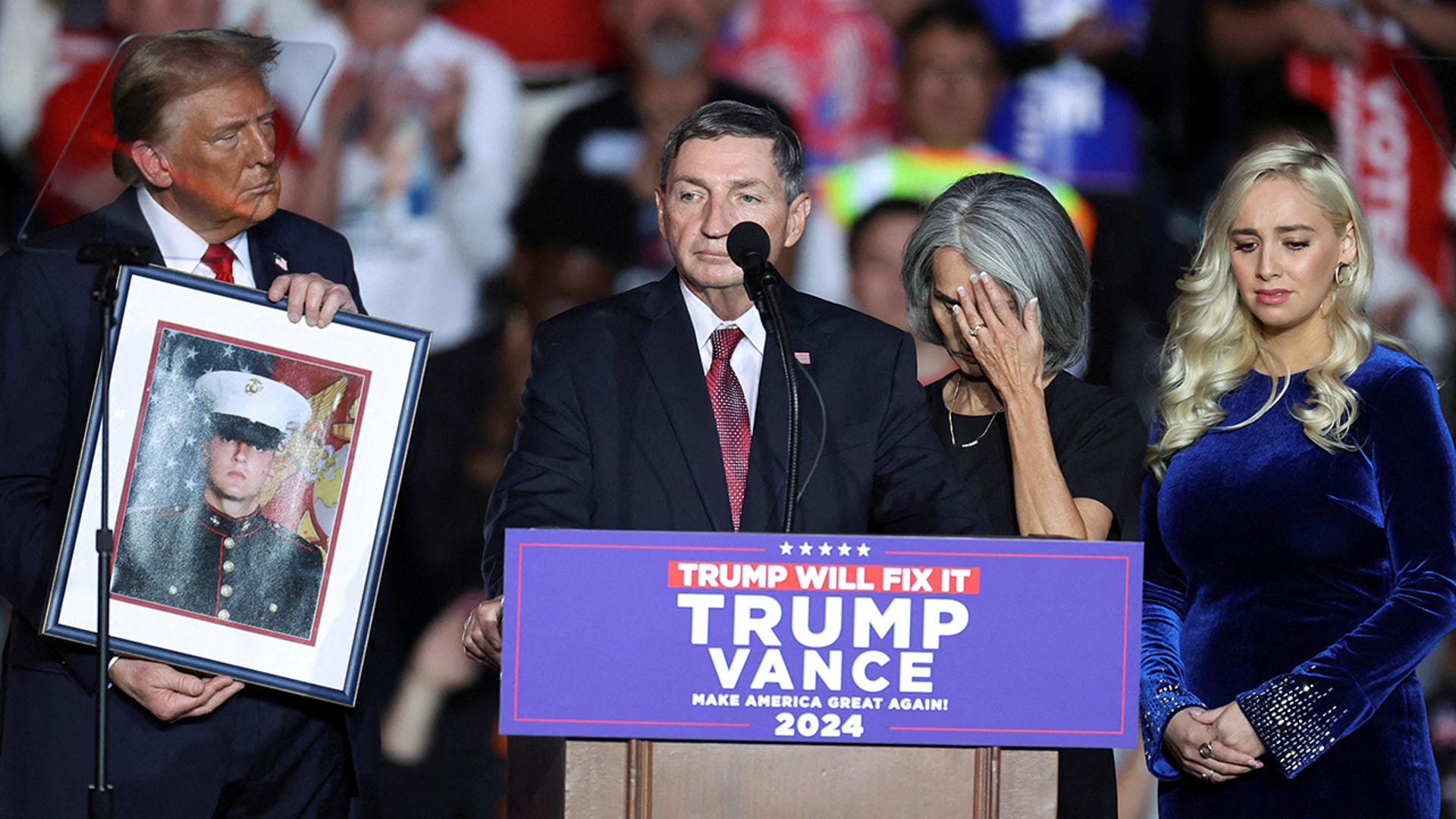 Republican presidential nominee and former President Donald Trump holds a portrait of Nicholas Douglas Quets