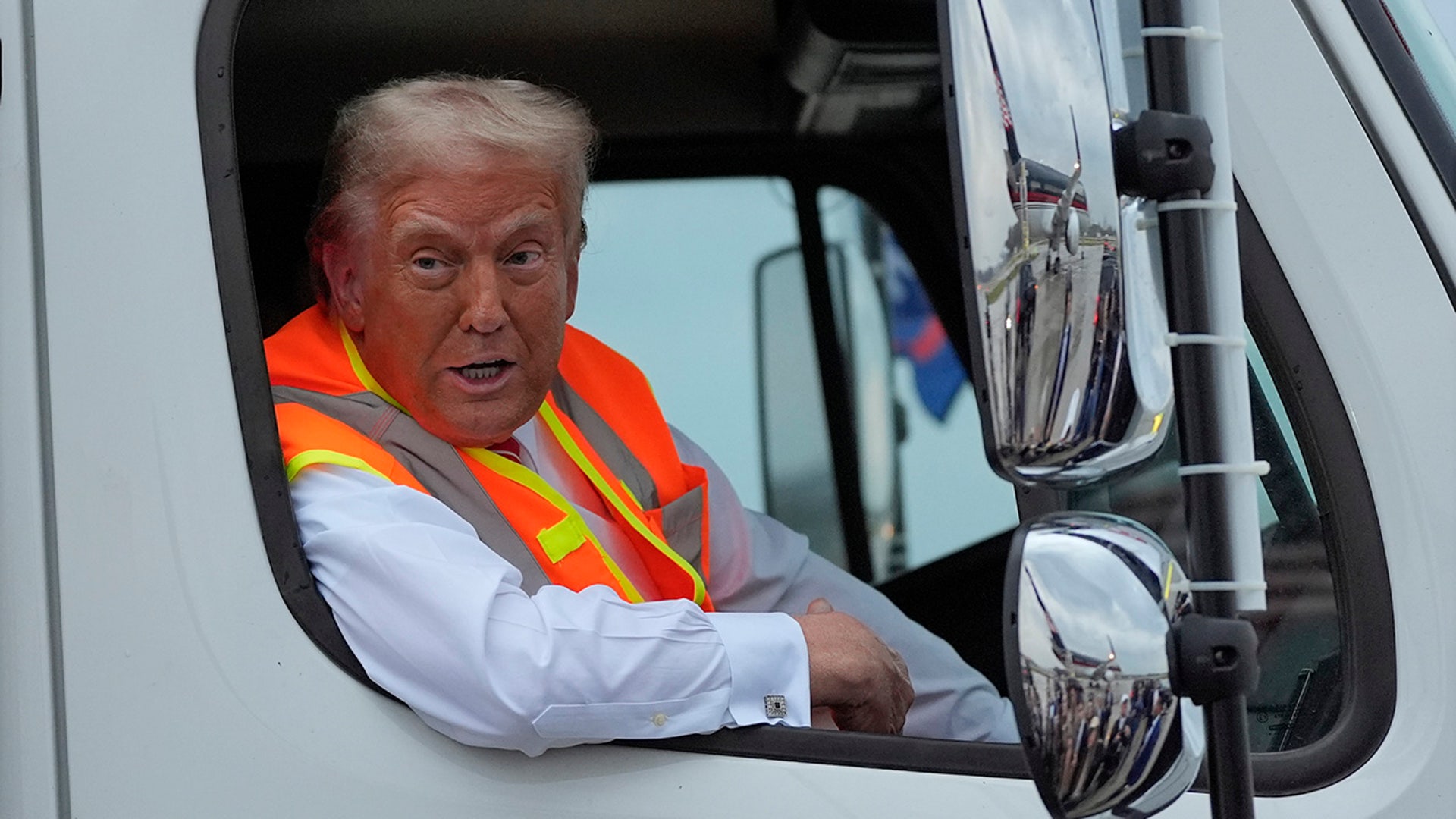 Republican presidential nominee former President Donald Trump talks to reporters as he sits in a garbage truck