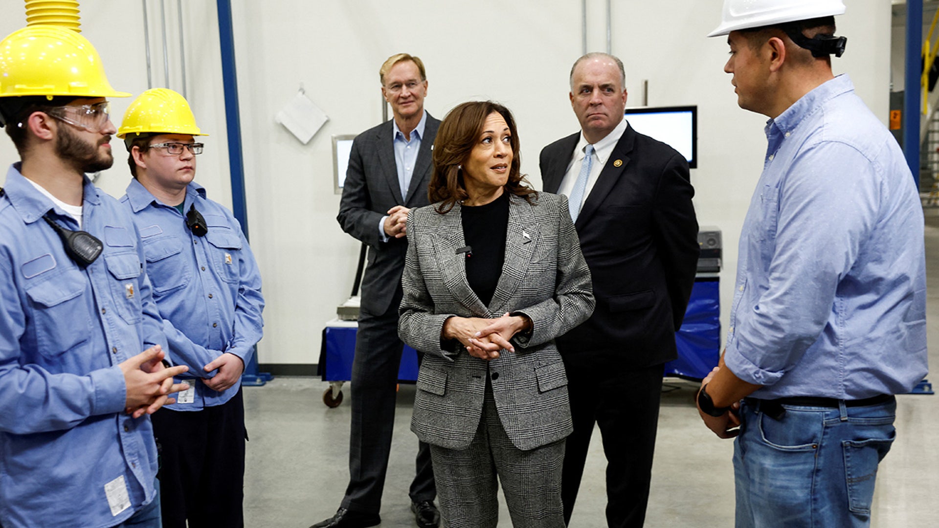 Democratic presidential nominee U.S. Vice President Kamala Harris meets with employees, with U.S. Rep. Dan Kildee and Corning CEO Wendell Weeks looking on