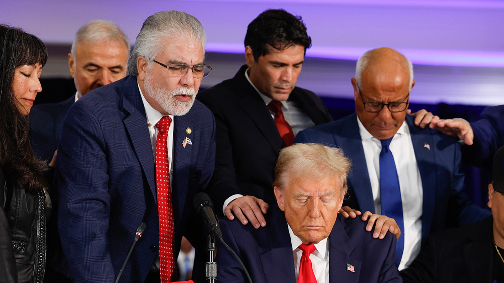 People pray with Republican presidential nominee, former President Donald Trump during a roundtable discussion at the Latino Summit held at Trump National Doral Golf Club