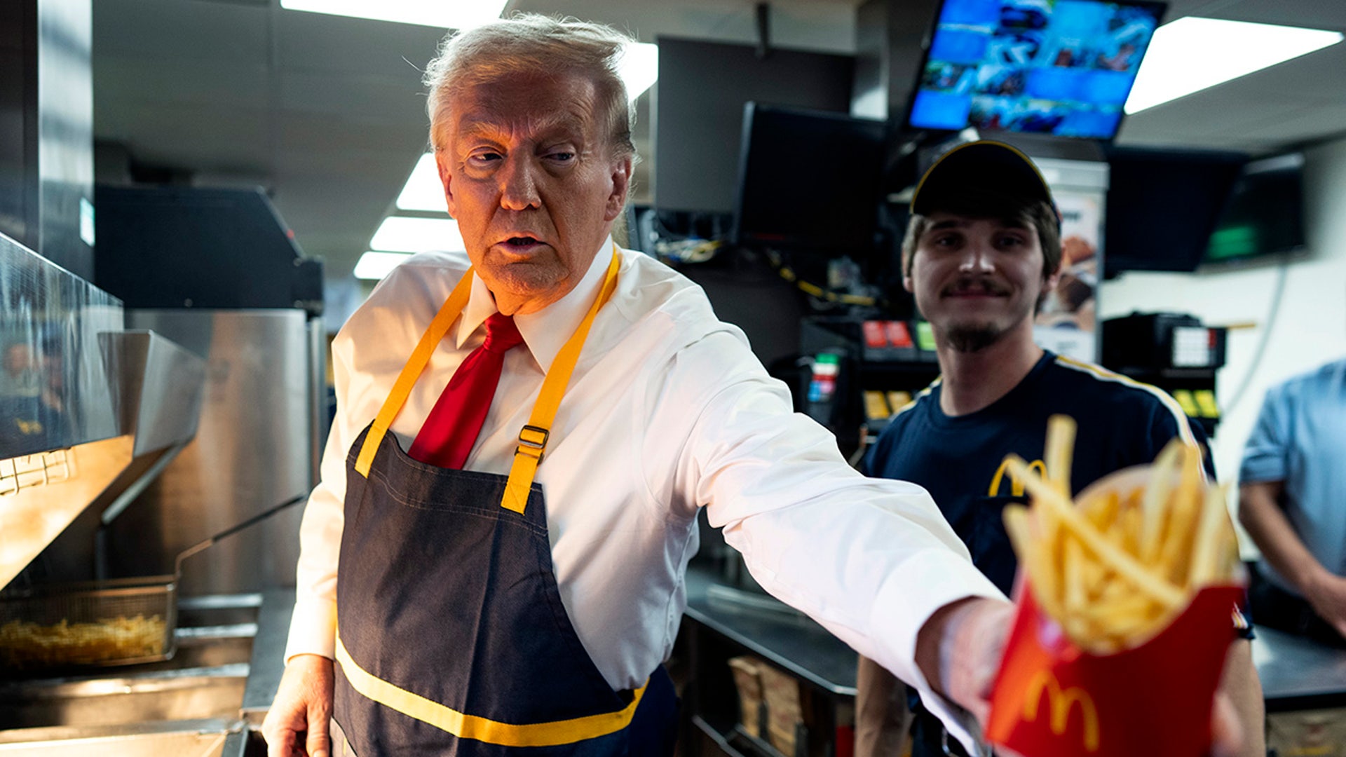 Republican presidential nominee and former President Donald Trump works behind the counter during a campaign event at McDonald's restaurant