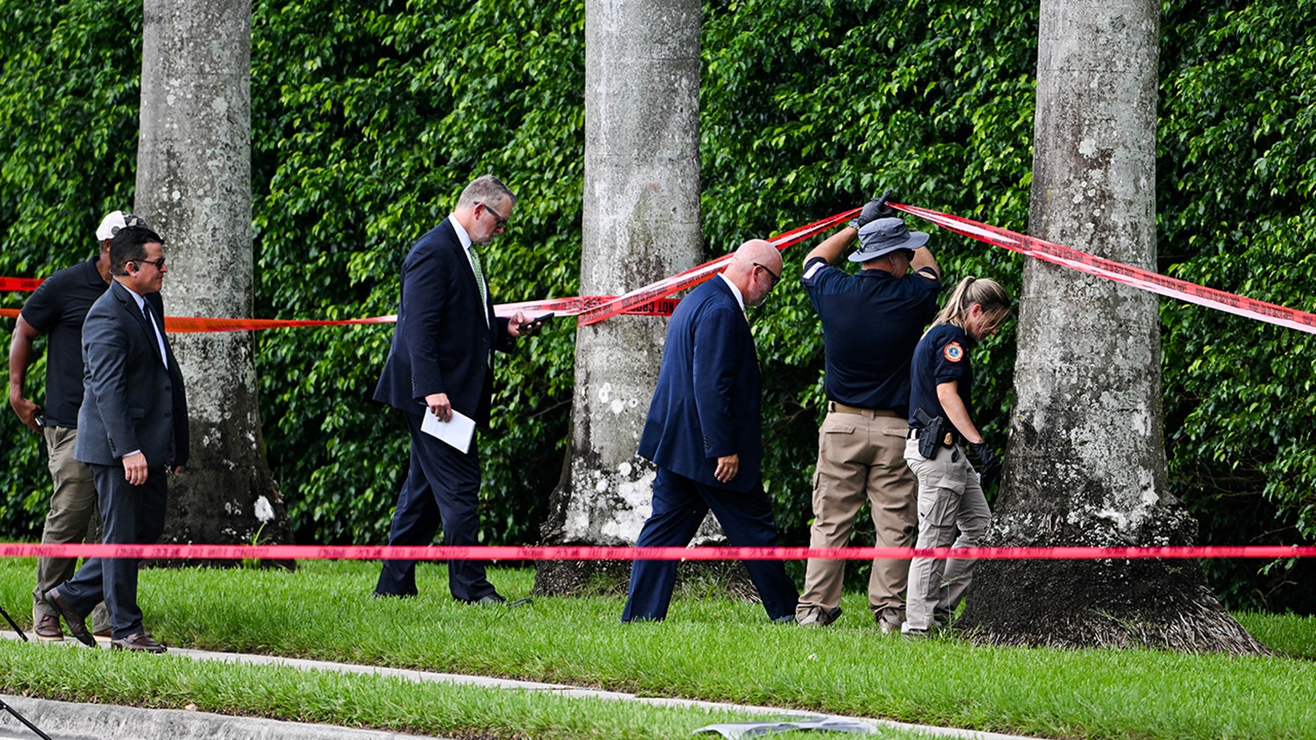 Law enforcement officials work at the crime scene outside the Trump International Golf Club