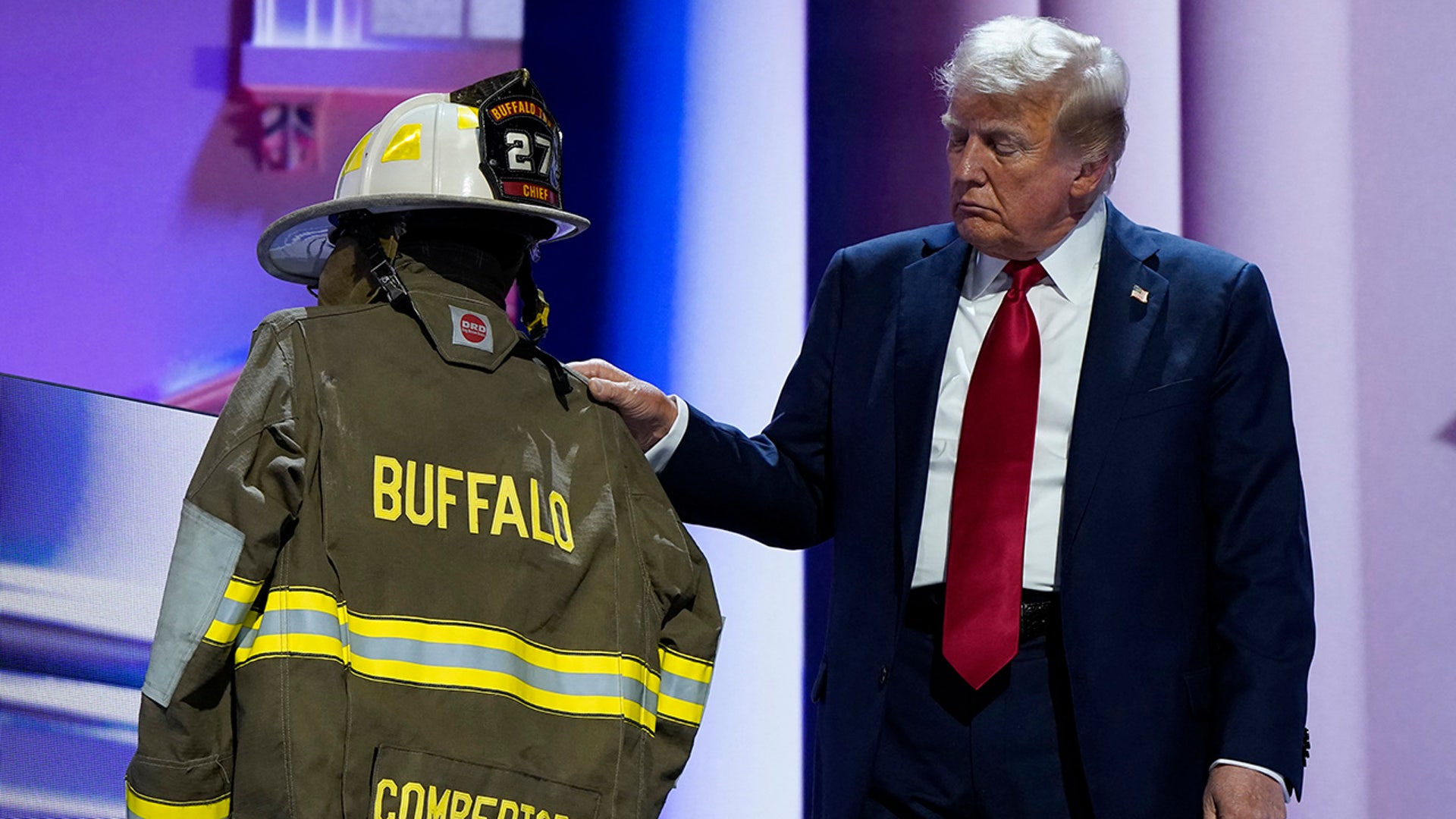 Republican presidential nominee and former President Donald Trump touches the turnout coat and helmet of former Buffalo Township Volunteer Fire Department chief Corey Comperatore