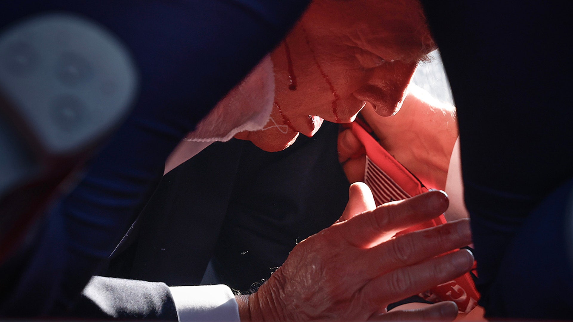 President Donald Trump is shown covered by U.S. Secret Service agents after an incident during a rally