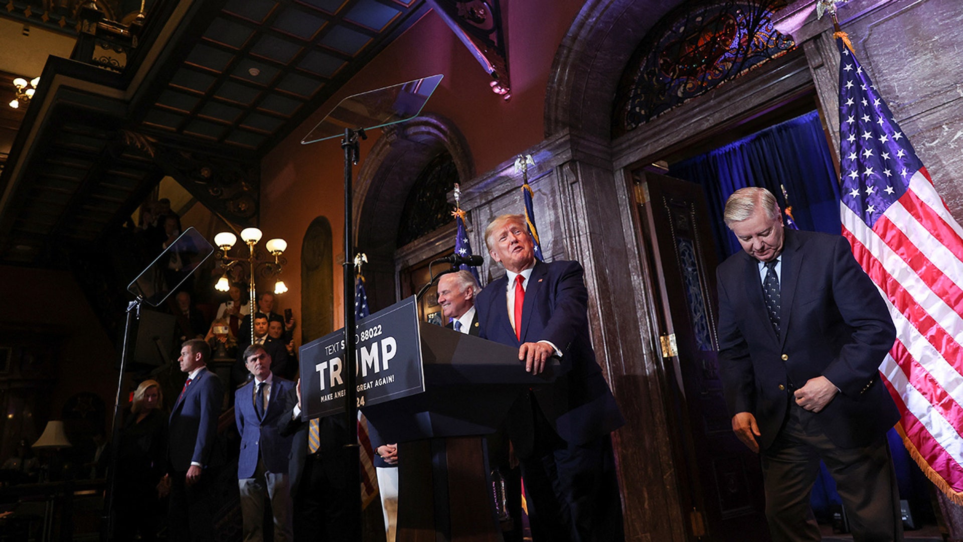 Former President Donald Trump speaks during a campaign stop unveiling his leadership team, while standing next to Senator Lindsey Graham