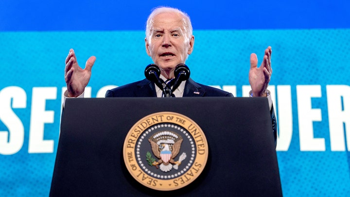 As Biden dodges press on Brazil trip, frustrated reporters resort to holding up signs with questions