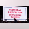 Republican presidential nominee and former U.S. President Donald Trump walks in front of a sign announcing technical difficulties during a rally at Huntington Place