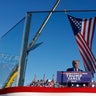 Republican presidential nominee and former President Donald Trump addresses a campaign rally from behind bullet resistant glass at the Butler Farm Show