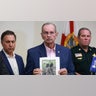 Palm Beach County Sheriff Ric Bradshaw holds a photograph of the rifle and other items found near where a suspect was discovered during a press conference regarding an apparent assassination attempt of former President Donald Trump