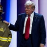 Republican presidential nominee and former President Donald Trump touches the turnout coat and helmet of former Buffalo Township Volunteer Fire Department chief Corey Comperatore