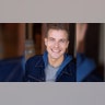 Paul Teal wears sweatshirt with denim jacket