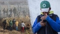 Migrants near the Rio Grande along the US-Mexico border in Juarez, Chihuahua state, Mexico, on Dec. 18, 2024, left, A migrant checks his phone, right. - Fox News