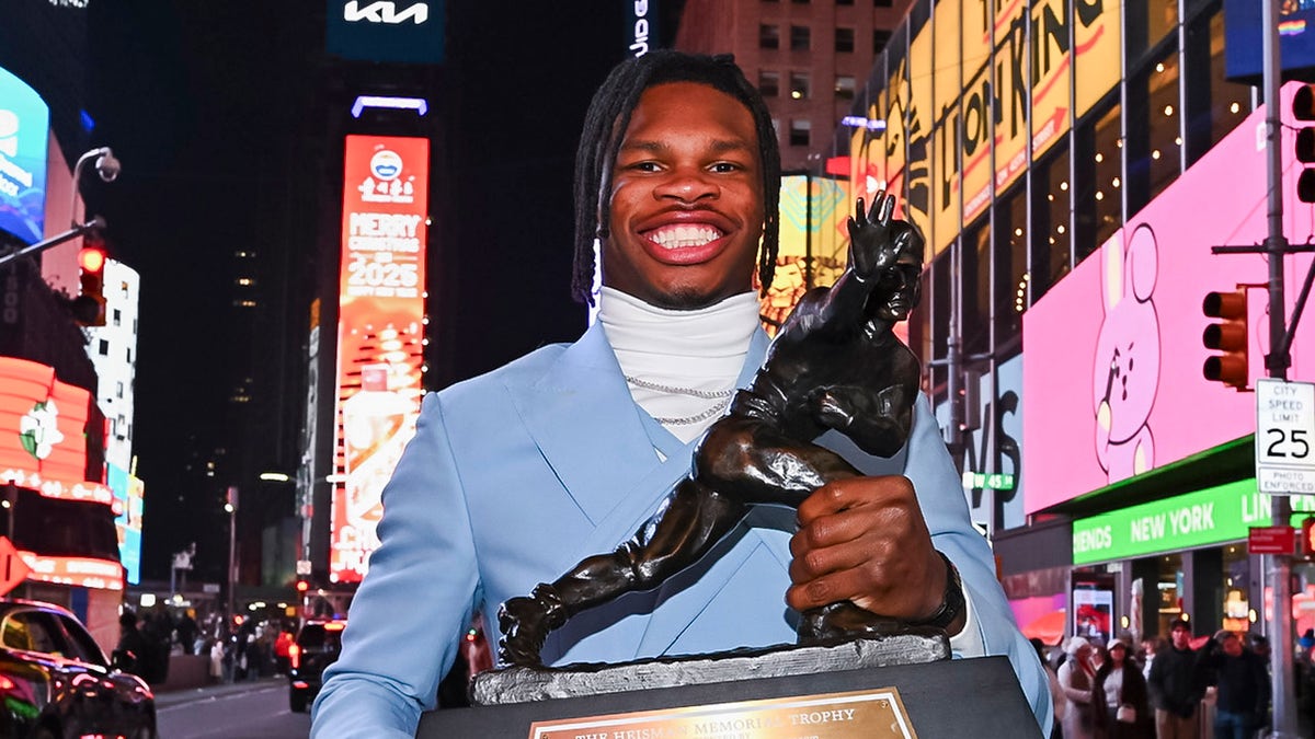 Travis Hunter smiles with the Heisman Trophy