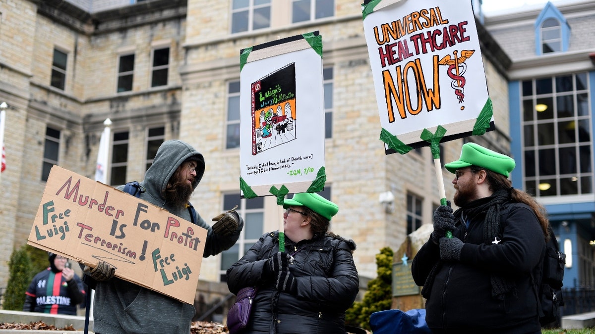 Adam Giesseman, left, of Piqua, Ohio, Ashlyn Adami, center, of South Bend, Ind., and Ethan Merrill of South Bend, Ind., protest outside the Blair County Courthouse after a hearing for Luigi Nicholas Mangione in Hollidaysburg, Pa., Thursday, Dec. 19, 2024.