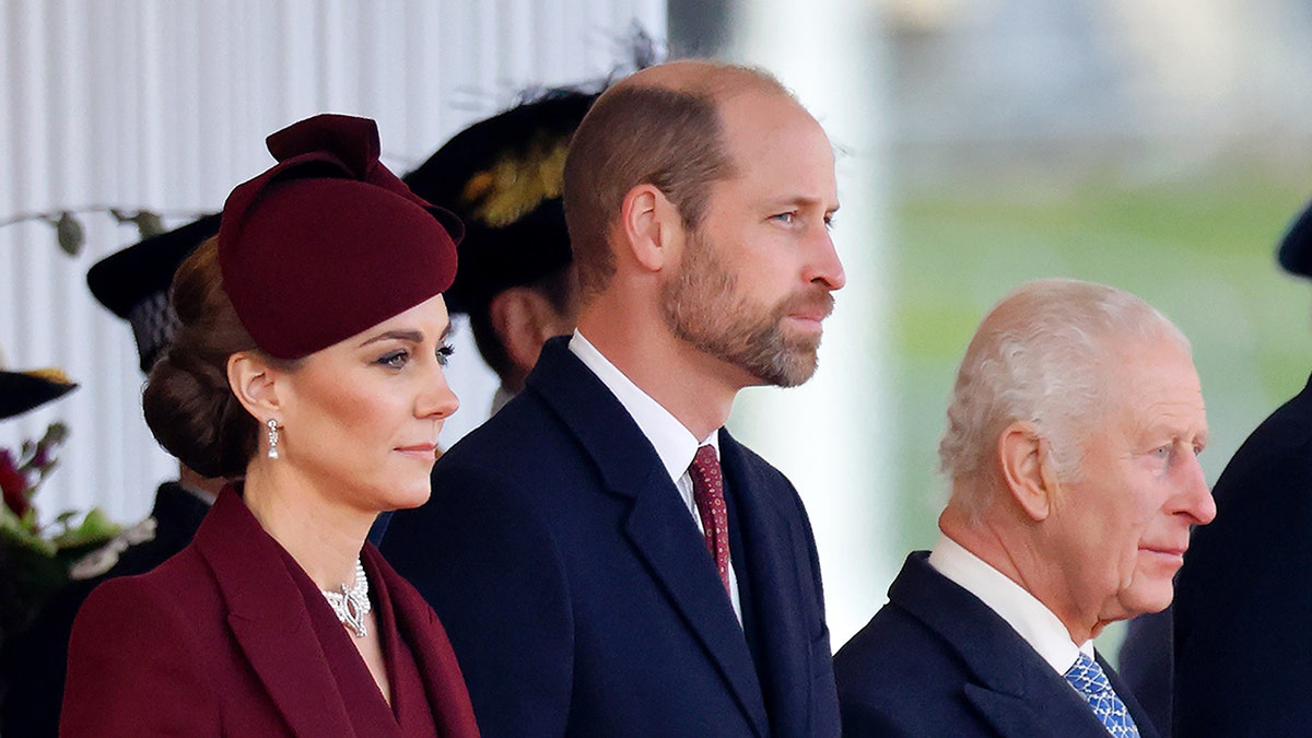 Kate Middleton wore a burgundy coat with a matching hat alongside Prince William and King Charles wearing suits.