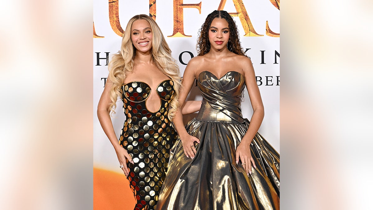 Beyoncé, con un vestido dorado con escote circular, sonríe junto a su hija Blue Ivy, con un vestido dorado sin tirantes, en el estreno de "Mufasa: El Rey León