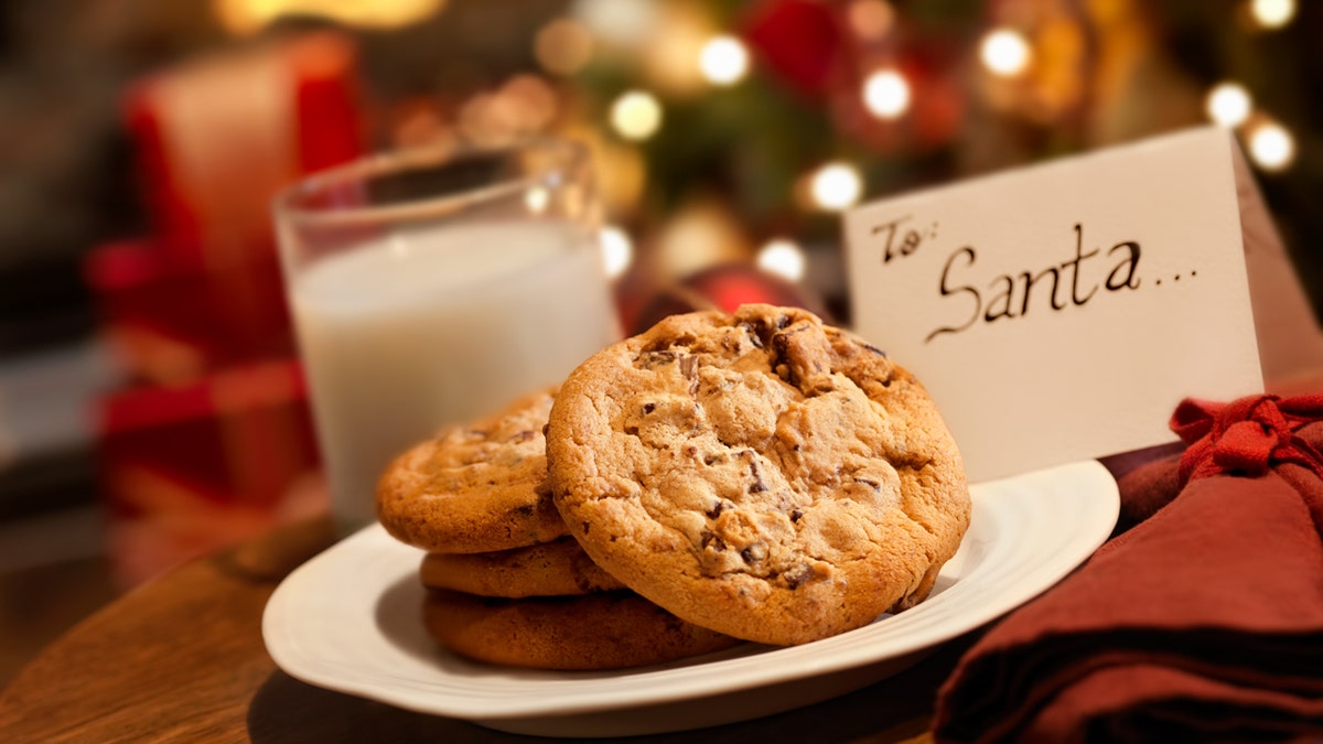 Cookies and milk wait for Santa Claus, with a card.