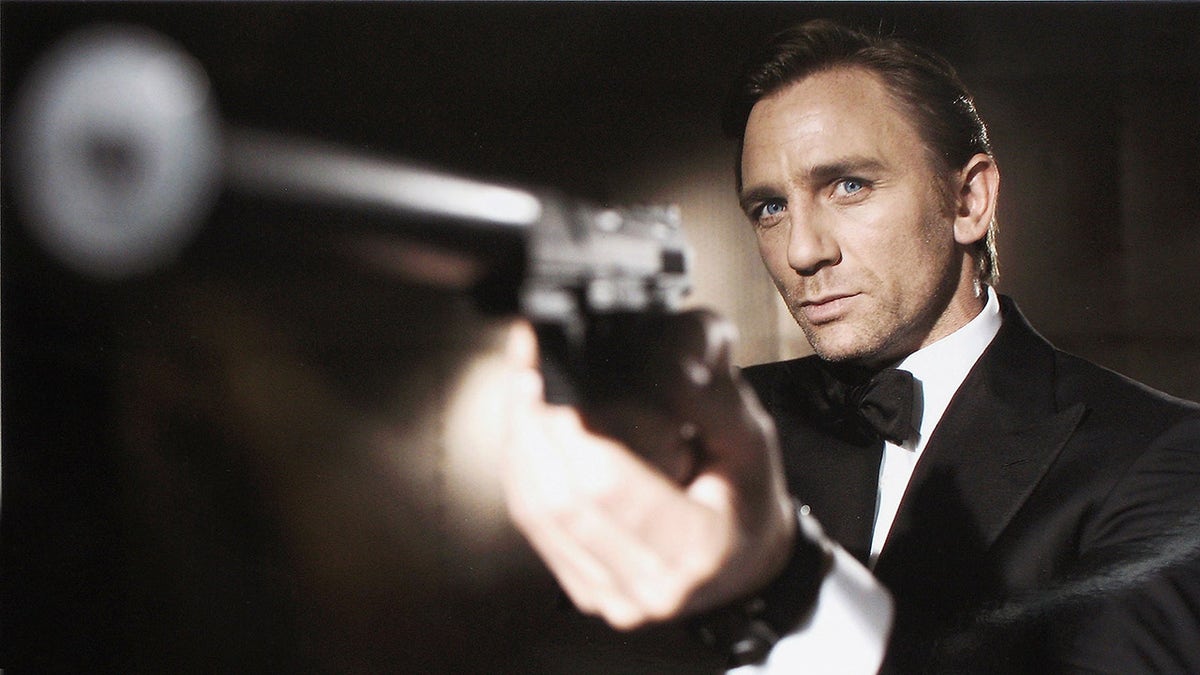 Daniel Craig holds a gun in the Casino Royale promo