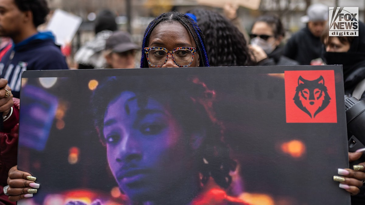 Individuals hold protest signs as they wait for Daniel Penny's arrival outside the Manhattan Criminal Courthouse