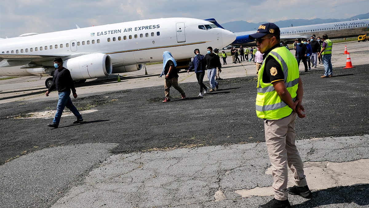 Police officers wait for migrants to be returned to Guatemala.