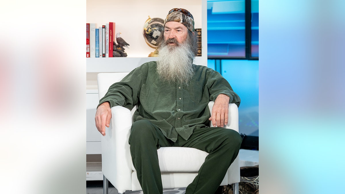 Phil Robertson of 'Ducky Dynasty' wears a green shirt and patterned scarf around his head, looking to his right