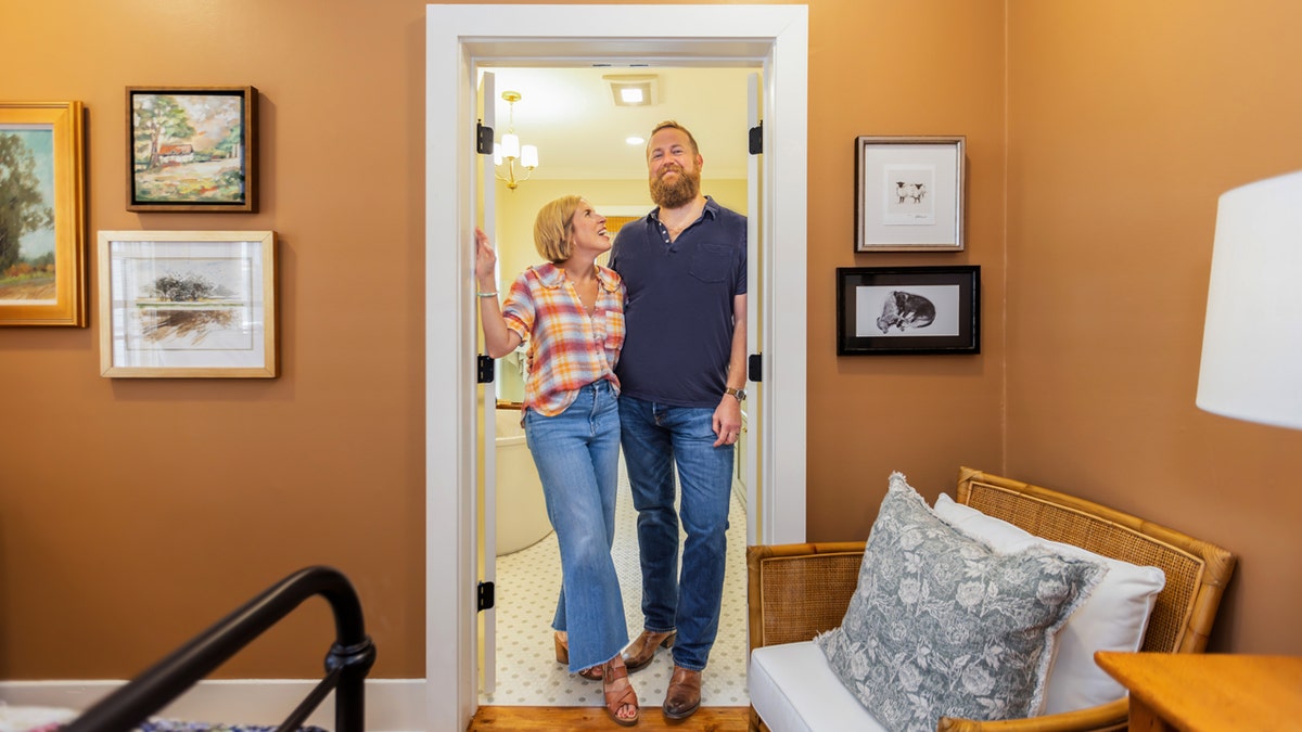 Erin and Ben Napier pose in a renovated house