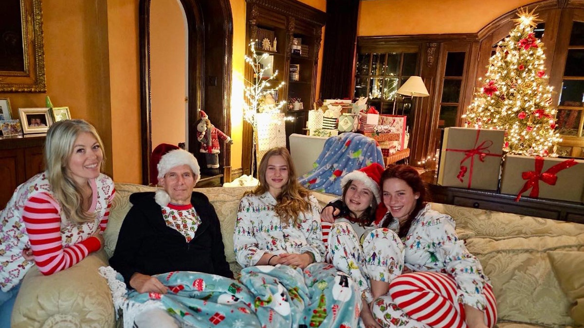 Michael Bolton in Christmas wear surrounded by family members.