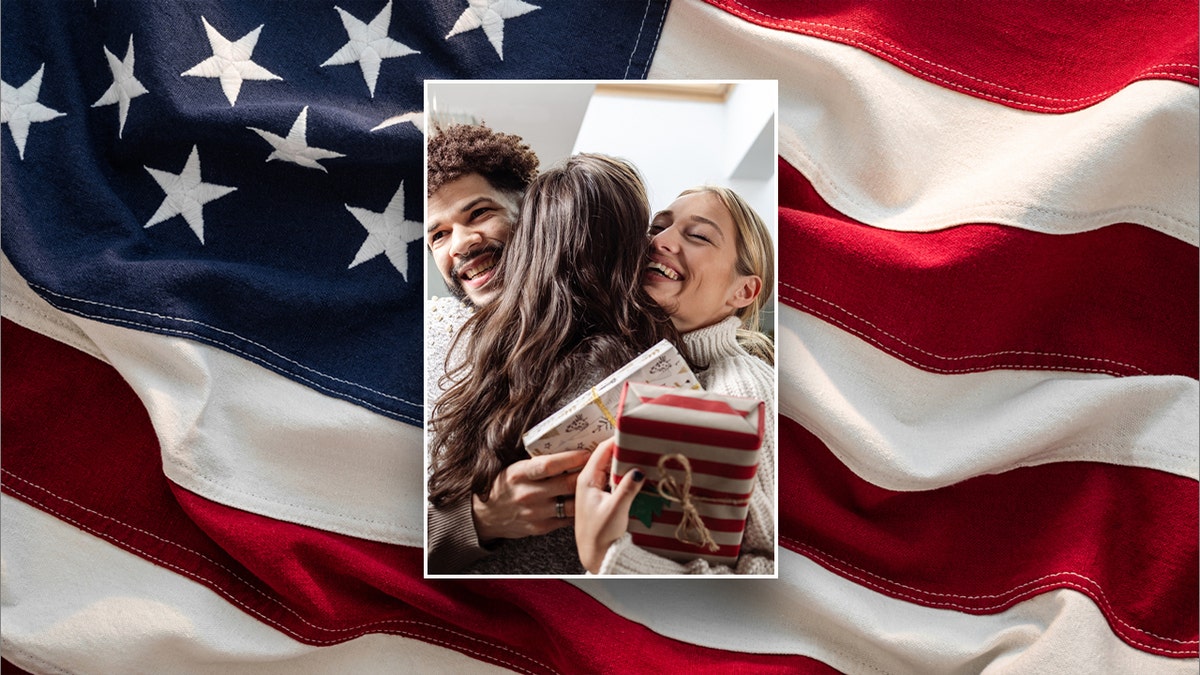 Friends hugging while holding Christmas gifts and an American flag background