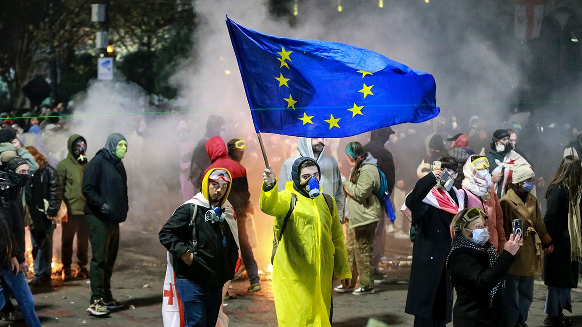 A protester waves an European Union flag during a rally outside the parliament to protest the government's decision to suspend negotiations on joining the European Union for four years in Tbilisi, Georgia, early Saturday, Nov. 30, 2024. (AP Photo/Zurab Tsertsvadze)