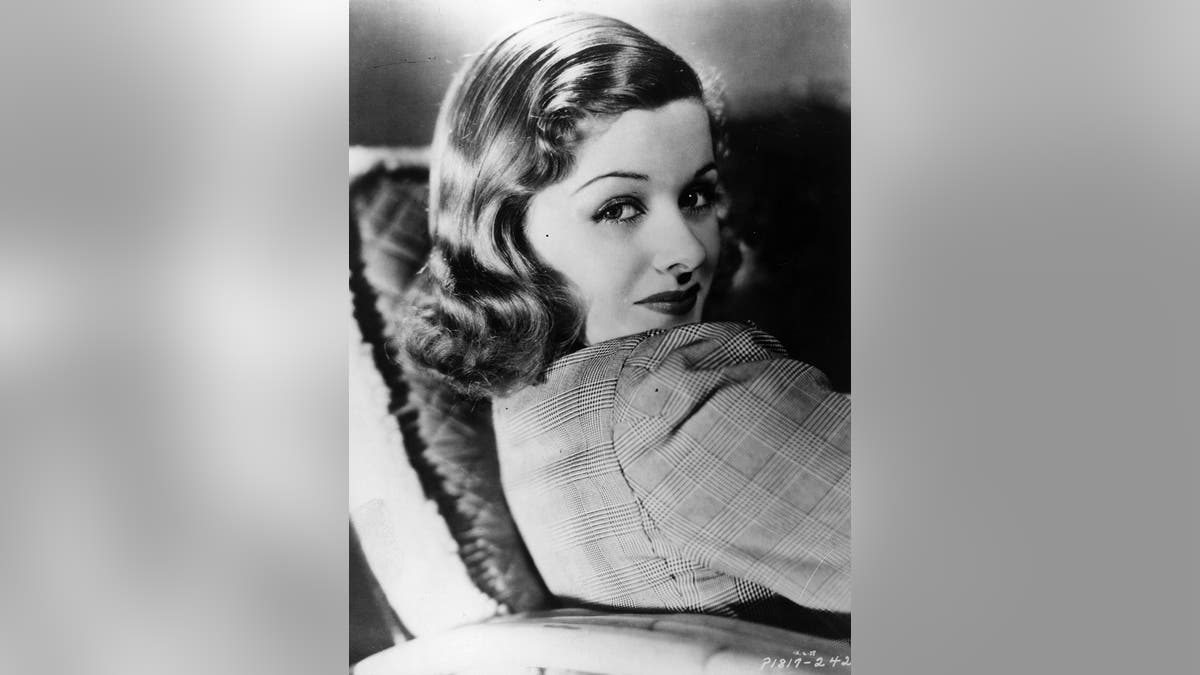 Joan Bennett regarde sur le côté d'une manière timide et glamour
