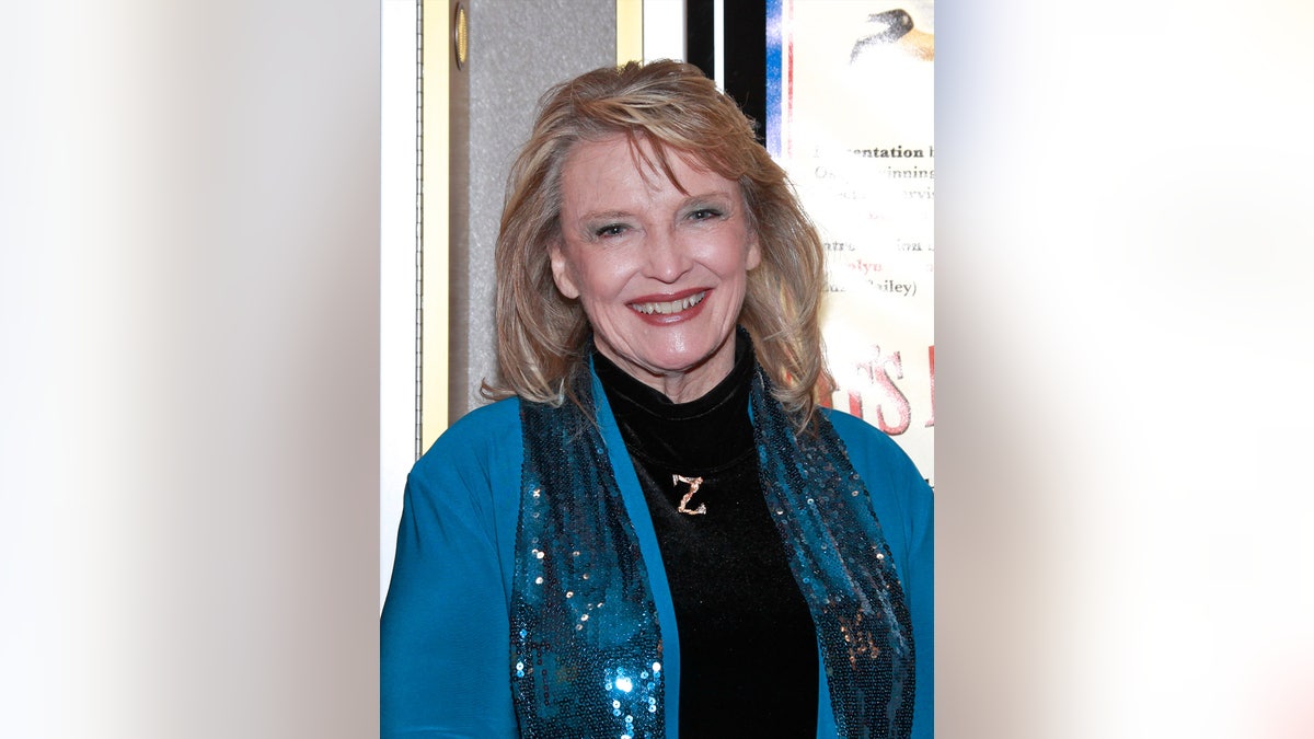 A close-up of Karolyn Grimes smiling in a blue coat.