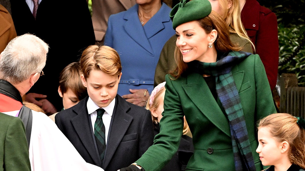 Kate Middleton greets a priest as she stands between Prince George and Princess Charlotte
