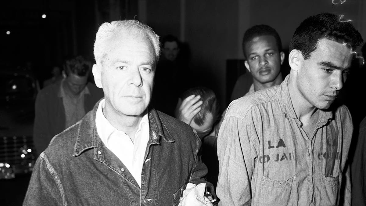 Un gros plan de Walter Wanger marchant à côté des prisonniers.
