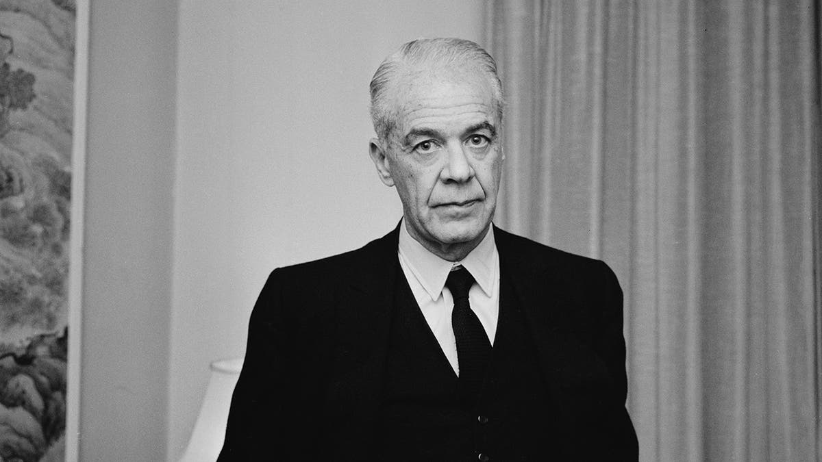 Un Walter Wanger au look sombre dans un costume noir