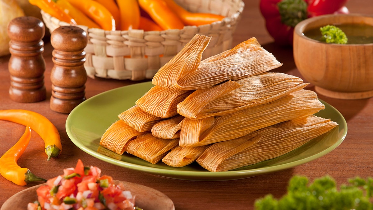 Traditional Tamales served with avocado and pico de gallo on mexican decoration