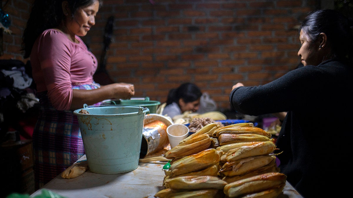 A group of women prepare typical tamales to offer to visitors who come to pray and stand guard at the offerings in the houses during the Day of the Dead.