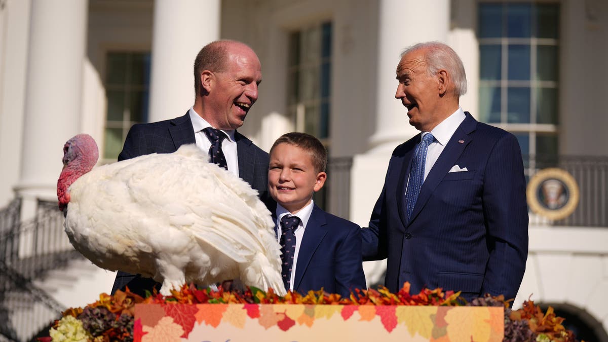 President Biden, right, pardons the National Thanksgiving Turkey Peach, alongside chair National Turkey Federation Chairman John Zimmerman and his son Grant during a ceremony on the South Lawn of the White House on Nov. 25, 2024 in Washington, D.C.